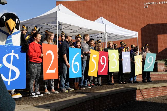 Clark students and Oswald reveal the total amount raised for Clark's Ensuring A Bright Future fundraising campaign during a campus celebration September 30.