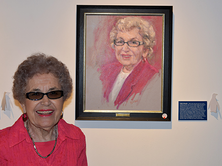 Sally Schaefer stands next to her portrait.