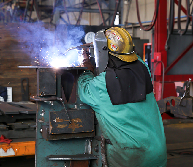 Kim Clements welds a rooster tail assembly at Gunderson Marine