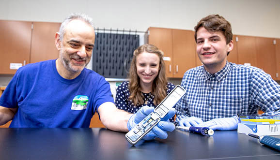Prof. Roberto Anitori and his students with a DNA sequencer.